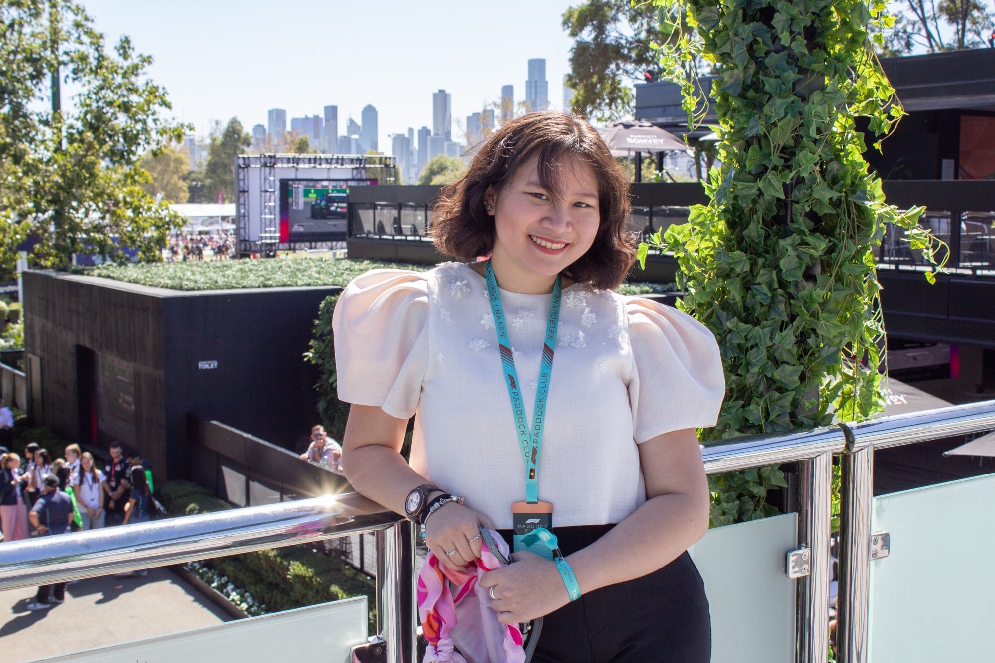 Faye smiles with from a balcony at a racing event