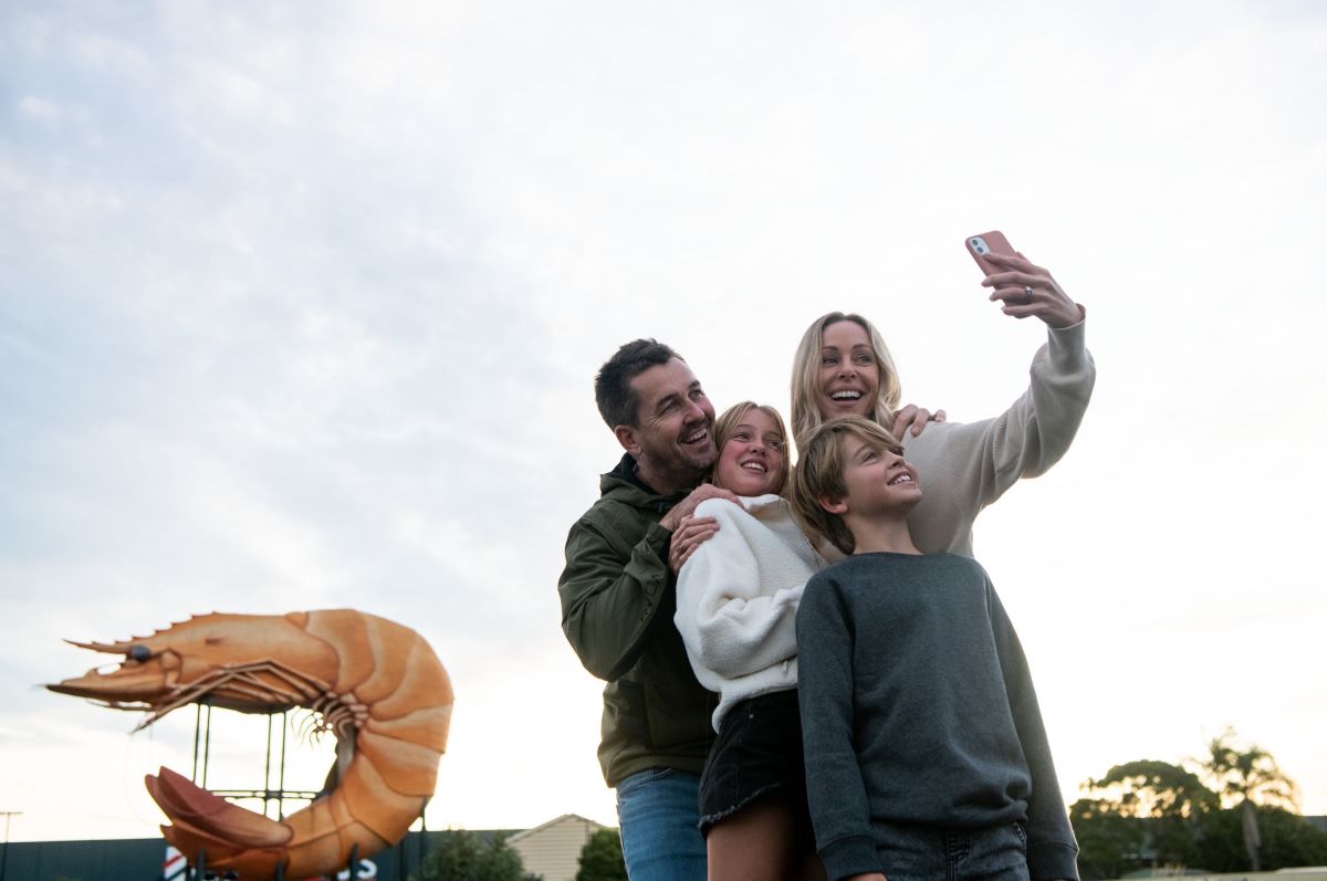 A young family taking a selfie in front of the Big Prawn