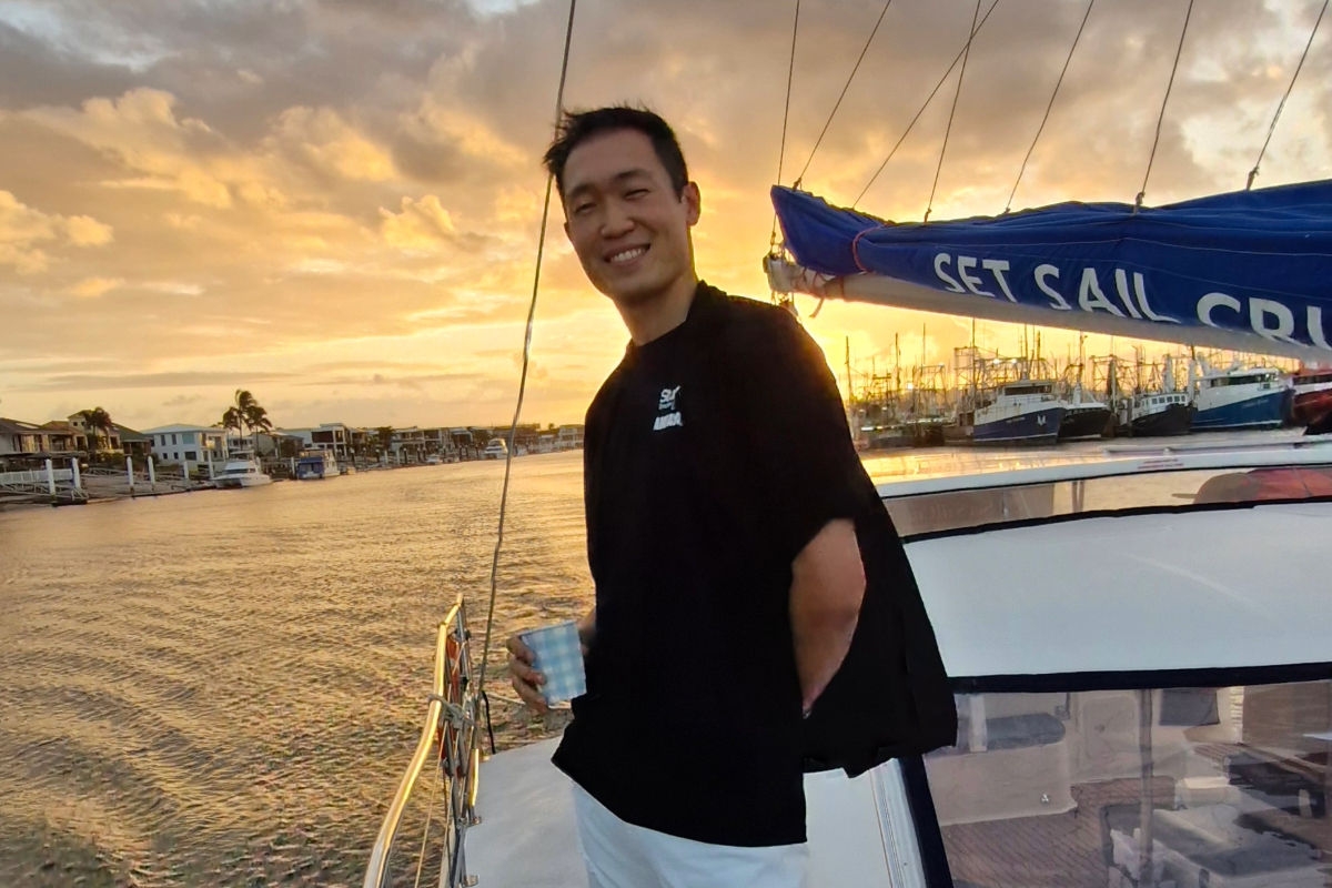 Lee smiling at sunset on a yacht